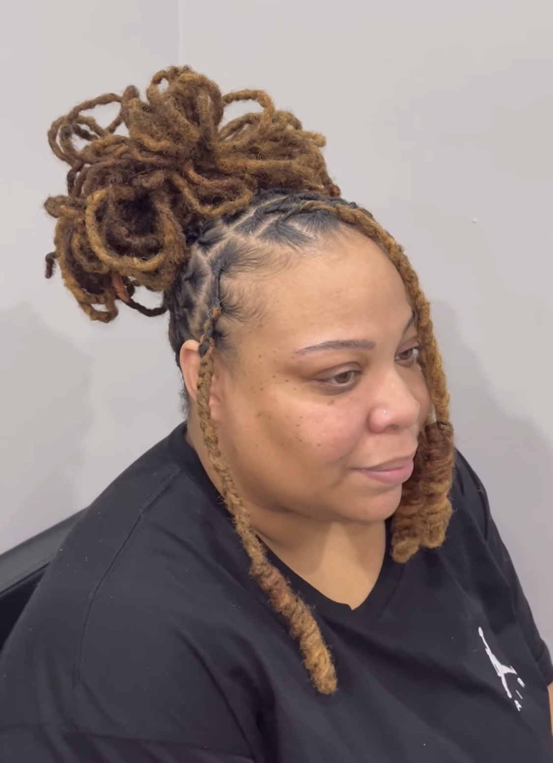 Locs styled into a full updo with a braided base